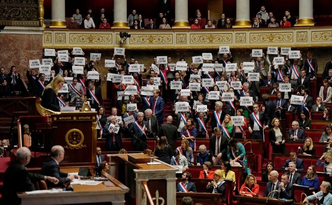 Los legisladores de extrema izquierda reaccionan mientras sostienen papeles que dicen: «64 años. Es no», en la Asamblea Nacional de París. Foto: AP