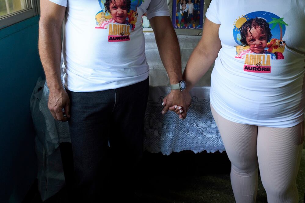 El matrimonio formado por Syntia Cáceres y José Martínez posa para fotos con camisetas con la foto de Aurore, la nieta de cuatro años de Syntia, quien fue colocada en un hogar de acogida en el estado de Georgia después de que su padre, el hijo de Cáceres, fuera detenido en julio, en su casa en Caracas. Foto: AP