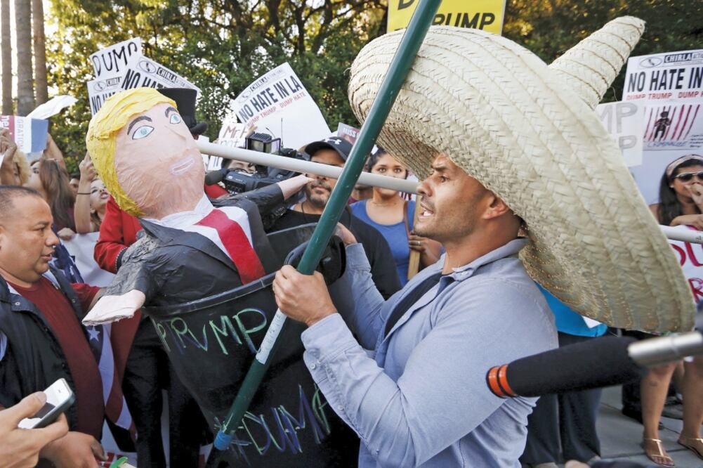 Manifestantes con una piñata de Donald Trump protestan afuera del hotel Luxe, en Brentwood, Los Ángeles, donde el magnate dio un discurso en julio pasado (LUCY NICHOLSON. REUTERS)