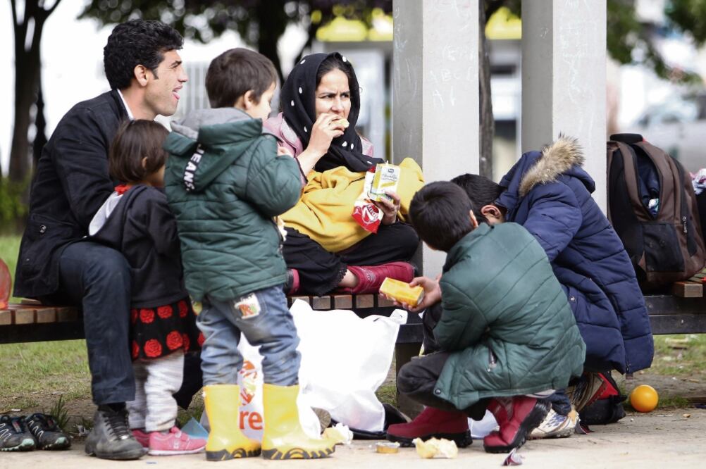Refugiados descansan para comer a su paso por Belgrado, Serbia, en su ruta hacia Europa (KOCA SULEJMANOVIC. EFE)