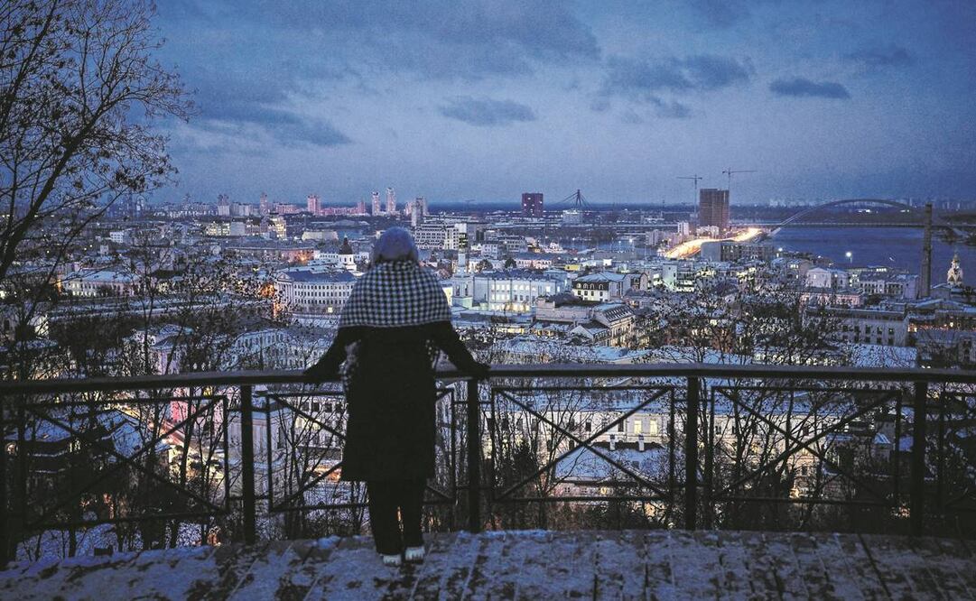 Una ucraniana observa el paisaje en el distrito Podil de Kiev. Miles de viviendas permanecen sin luz, tras los ataques rusos.Foto:Dimitar Dilkoff/AFP