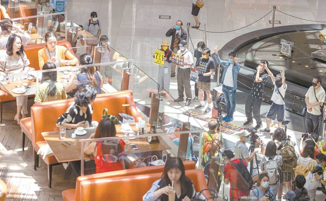 Manifestantes prodemocracia protestan en un centro comercial de Hong Kong contra la ley de seguridad que ayer aprobó el Parlamento chino. Foto: JEROME FAVRE. EFE