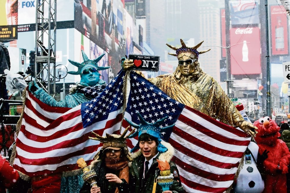 Personas disfrazadas de Estatuas de la Libertad posan para la foto en Times Square, en vísperas de la celebración del Año Nuevo en Manhattan, Nueva York. (EDUARDO MUÑOZ. REUTERS)