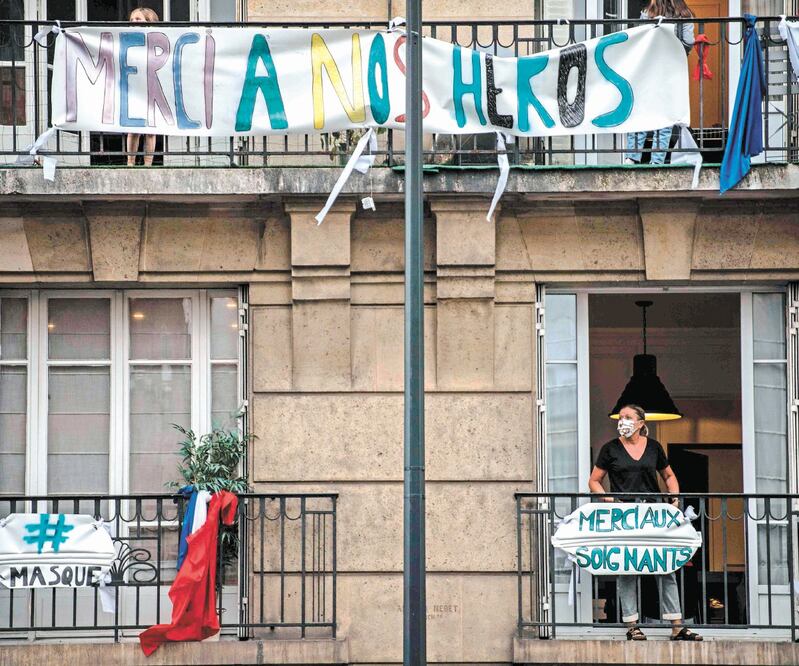 Ciudadanos franceses salieron a sus balcones y ventanas alrededor de las 20:00 horas, y con la bandera gala y mensajes en pancartas manifestaron su apoyo a los empleados de la salud en Saint-Mande, un suburbio de París. MARTIN BUREAU. AFP 