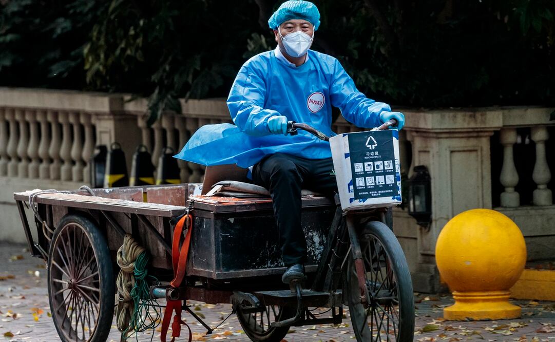 Un empleado de mantenimiento monta en bicicleta en una comunidad residencial bajo confinamiento en Shanghái. Foto: EFE