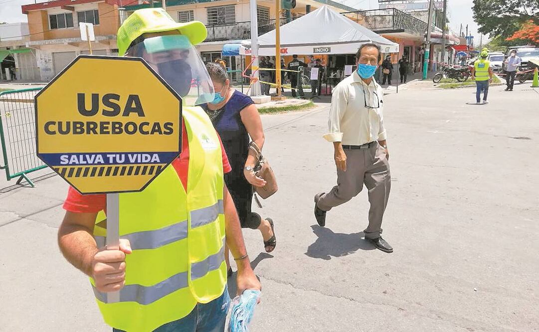 Voluntarios de chalecos y gorras amarillas advierten a la gente que la pandemia aún no termina. Foto: ESPECIAL