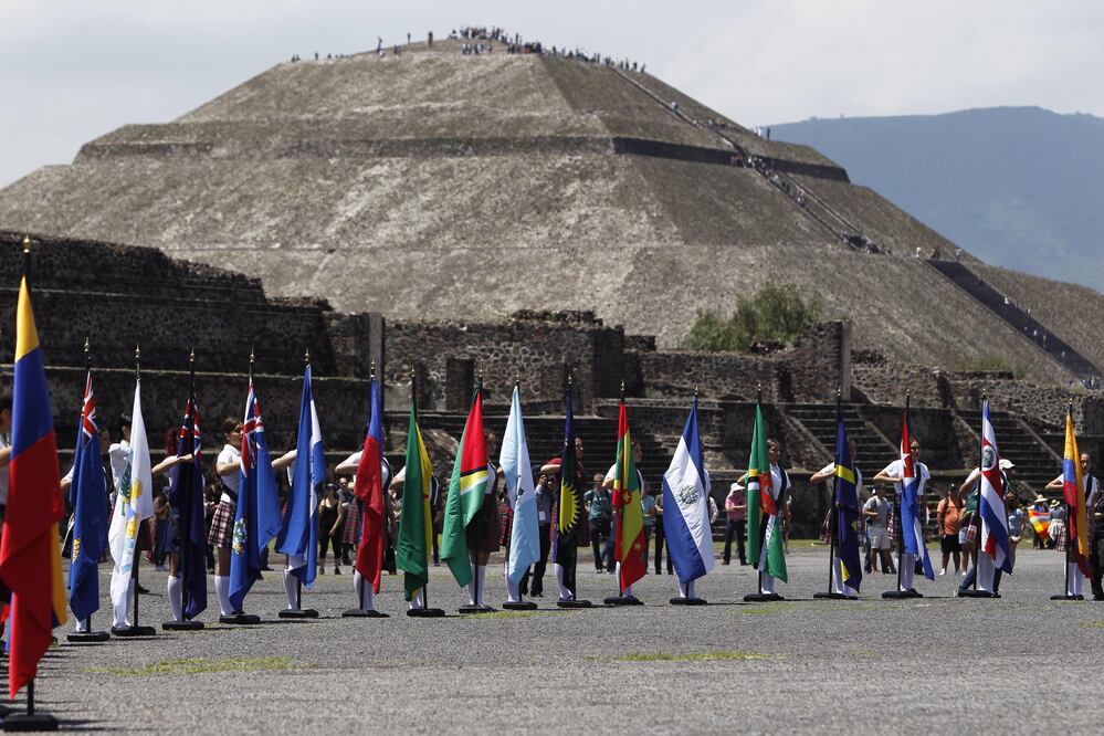 Vista de las banderas de diferentes países en Teotihuacán durante la ceremonia del fuego que enciende el pebetero, el cual viajó a Colombia para los XXIII Juegos Centroamericanos y del Caribe de Barranquilla 2018 (EFE)