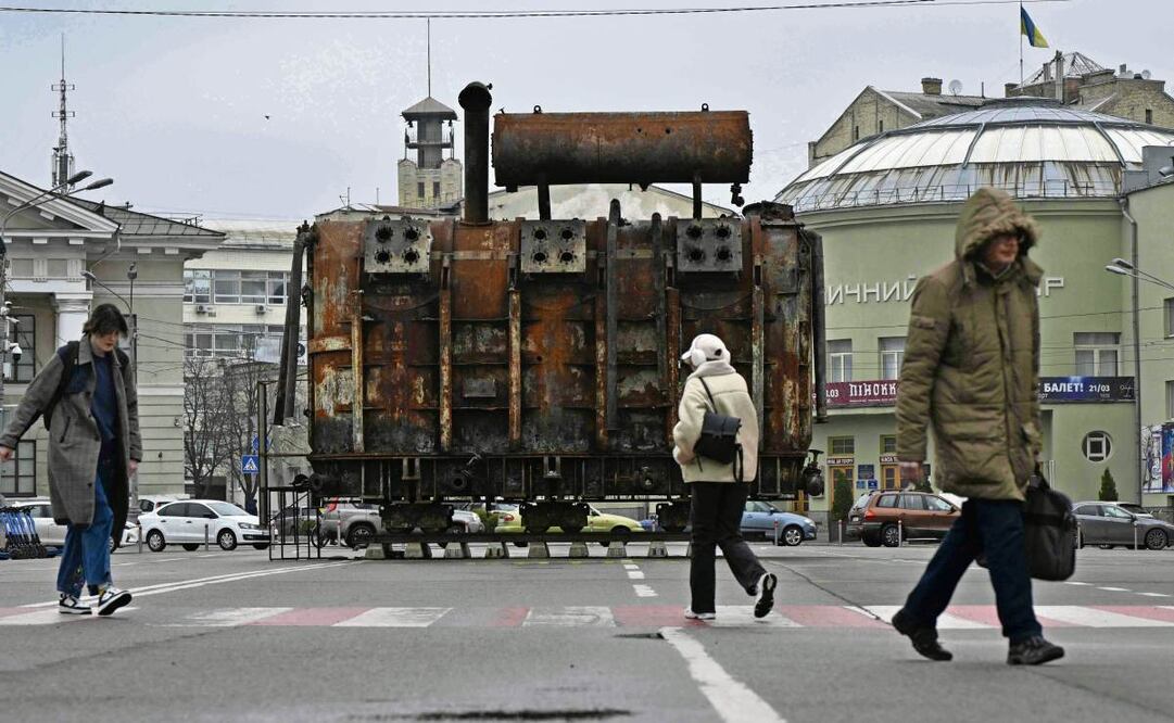 Ucranianos frente a un equipo recuperado de una central eléctrica atacada por las fuerzas rusas y expuesto en el barrio de Podil en Kiev. (31/03/2025) Foto: Genya Savlov | AFP