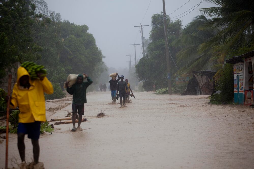 Residentes caminan en calles inundadas mientras regresan a sus casas en Leogane, Haití (Foto: AP)