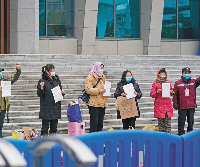 Pacientes curados de la neumonía por el coronavirus muestran sus certificados de alta hospitalaria en el distrito Wuchang de Wuhan, en Hubei. CHENG MIN. XINHUA
