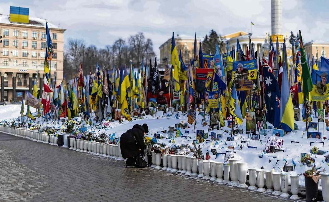 Una ucraniana arregla flores depositadas en un monumento improvisado a los soldados de Ucrania y extranjeros caídos en la Plaza de la Independencia, en el centro de Kiev, durante la invasión rusa.  Foto: Henry Nicholls / AFP