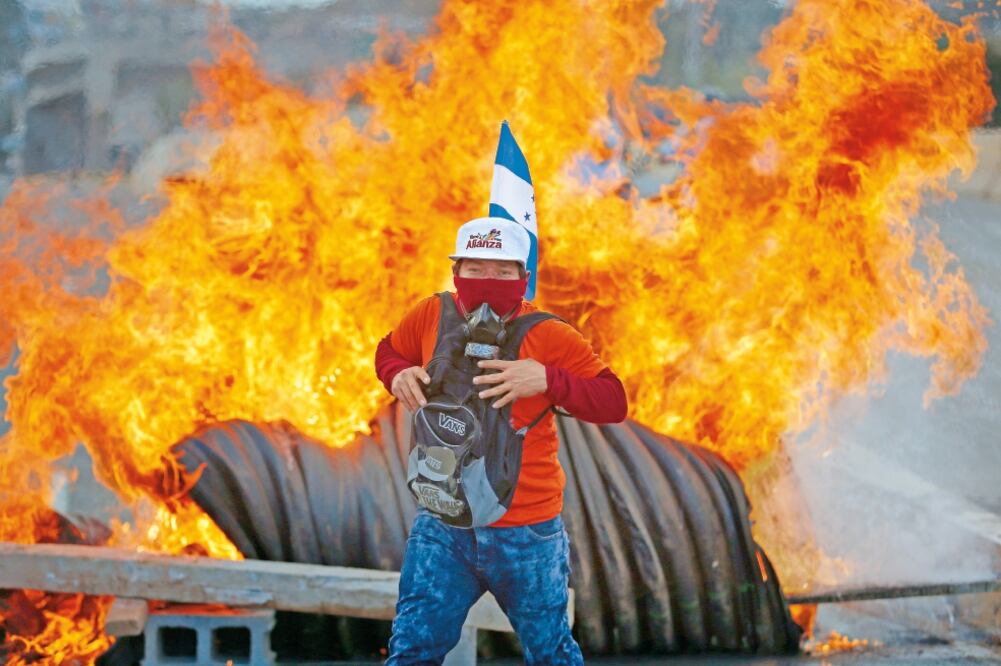 Los simpatizantes de la oposición quemaron barricadas y se enfrentaron con la policía, que les lanzó gases lacrimógenos para impedir que llegaran a al estadio donde Juan Orlando Hernández tomaba protesta. (EDUARDO VERDUGO. AP)