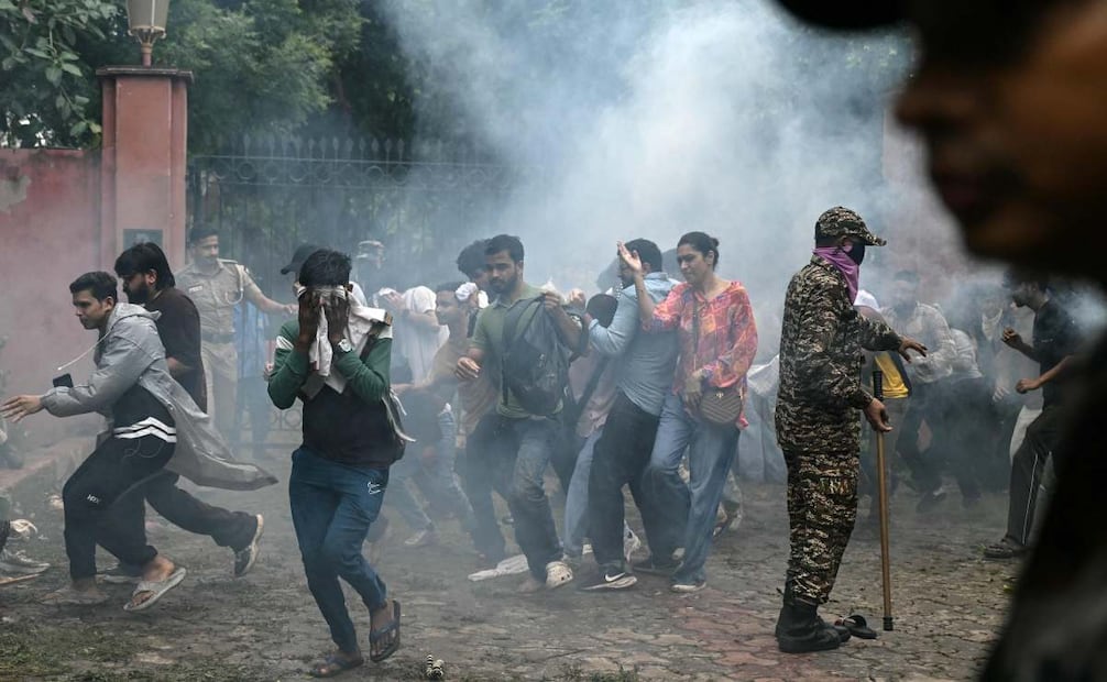 Partidarios del Cockroach Janta Party (CJP) se dispersan después de que la policía disparara gases lacrimógenos durante una protesta en Nueva Delhi, el 20 de julio de 2026, para exigir la dimisión del ministro de Educación de la India, Dharmendra Pradhan, debido a presuntas irregularidades en el examen NEET. La policía antidisturbios india cargó con porras contra los manifestantes en Nueva Delhi cuando estos intentaban marchar hacia el Parlamento el 20 de julio, intensificando así la protesta por las irregularidades en importantes exámenes. Foto: AFP