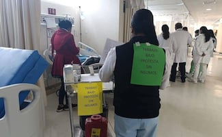 Trabajadores del ISSSTE en Oaxaca se colocan mensajes en la espalda para denunciar falta de insumos y medicamentos
