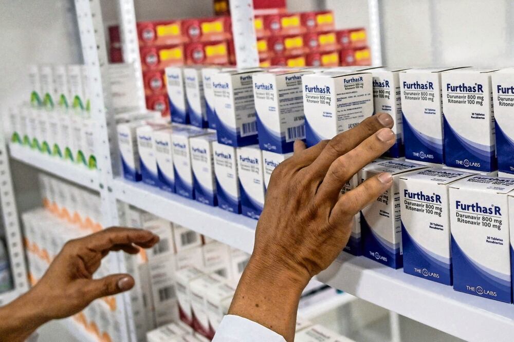 Un hombre coloca medicamentos en una clínica para pacientes con VIH en Cali, Colombia. Foto: AFP