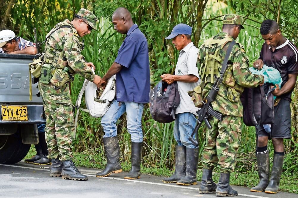 Soldados colombianos revisan las mochilas de la gente, en la municipalidad de Tumaco, donde hay una operación para buscar a los asesinos de los periodistas (RAÚL ARBOLEDA. AFP)