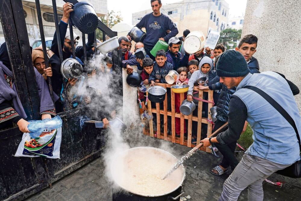 Palestinos esperan recibir comida en un centro de donación en el campo de refugiados de Rafah, en la Franja de Gaza. Foto: Mahmud Hams / AFP