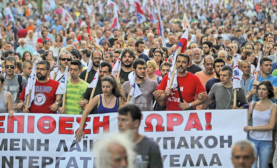 Varios miembros del sindicato comunista Pame participaban ayer en una protesta contra el segundo paquete de reformas acordado con la eurozona, frente al Parlamento de Atenas (ORESTIS PANAGIOTOU. EFE)