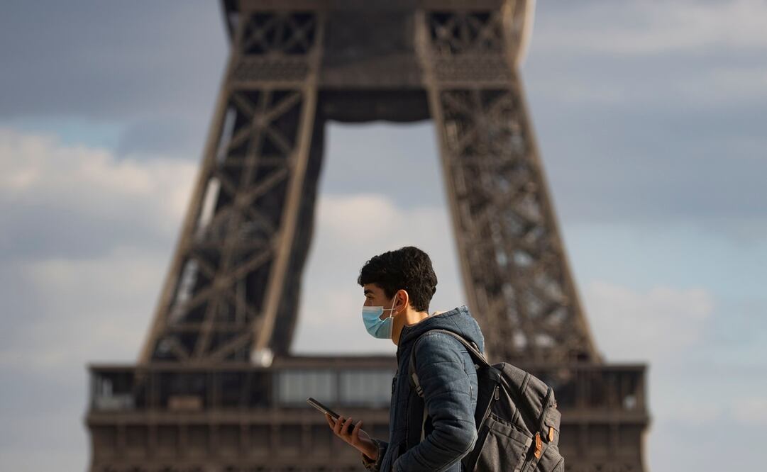 Un joven habitante de París pasea frente a la Torre Eiffel en vísperas del análisis que la municipalidad de esta ciudad hará para un eventual confinamiento obligatorio para reducir los contagios de Covid-19. Foto: EFE/EPA/IAN LANGSDON