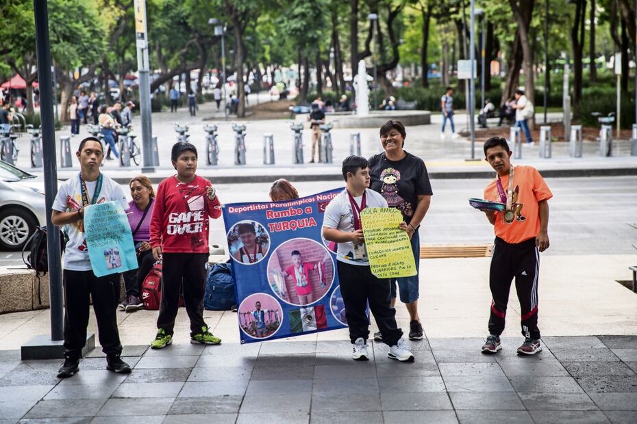 Del pecho de los deportistas cuelgan medallas, mientras que sus manos sostienen una canasta de dulces que intercambian por una moneda. Foto: Germán Espinoza
