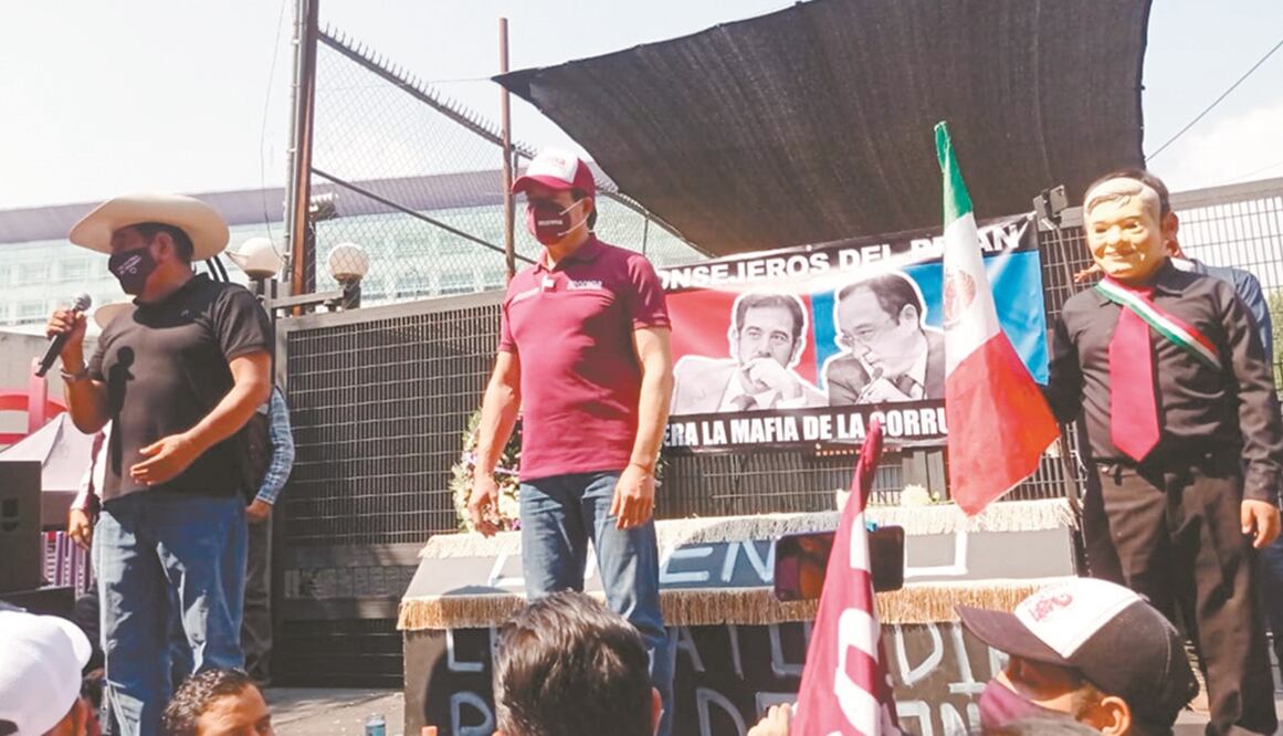 Félix Salgado, aspirante a la gubernatura de Guerrero, y Mario Delgado, líder de Morena, ayer en el INE. Atrás, un féretro con la frase: “Lorenzo cuenta tus días rata demonio”. Foto: INE