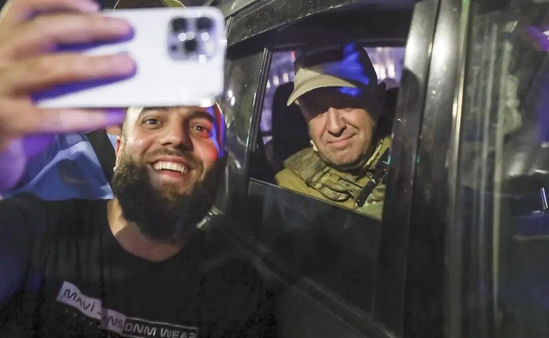 Yevgeny Prigozhin, propietario de la compañía militar Grupo Wagner, a la derecha, se sienta en un vehículo militar y posa para una selfie con un civil en una calle de Rostov, Rusia. Foto: AP
