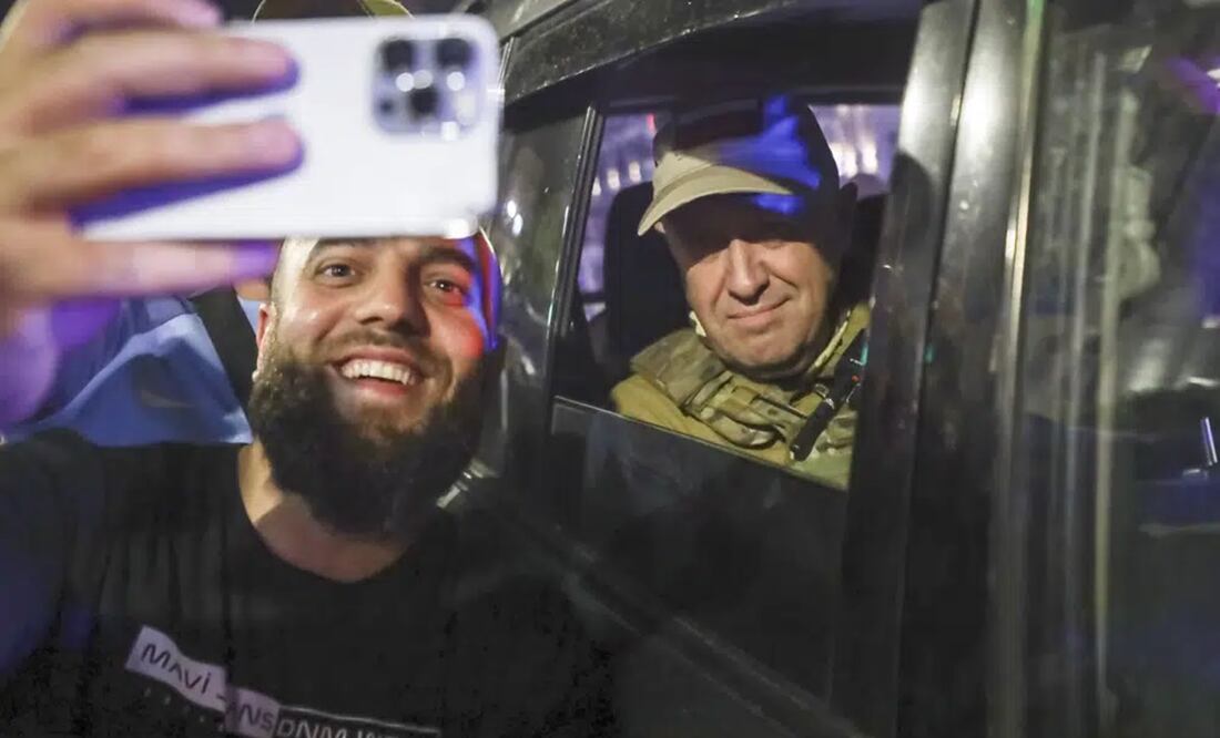 Yevgeny Prigozhin, propietario de la compañía militar Grupo Wagner, a la derecha, se sienta en un vehículo militar y posa para una selfie con un civil en una calle de Rostov, Rusia. Foto: AP