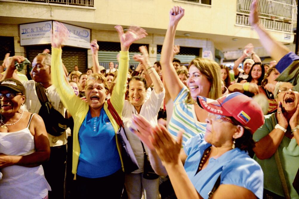 Simpatizantes de la oposición celebraban anoche, en Caracas, el cierre de casillas, luego de que la CNE ordenara atrasarlo una hora (FEDERICO PARRA. AFP)
