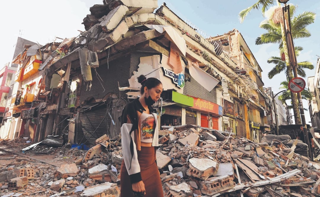 Una colombiana pasa junto a escombros de un edificio derrumbado tras el terremoto en Pereira. Foto: Jaime Saldarriaga/ AFP