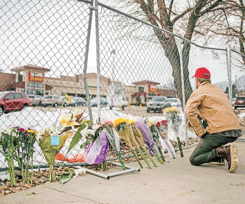 Una persona homenajea a las víctimas del ataque en un supermercado en Boulder, Colorado; 10 personas fueron asesinadas el lunes. Foto: Chet Strange/ AFP.