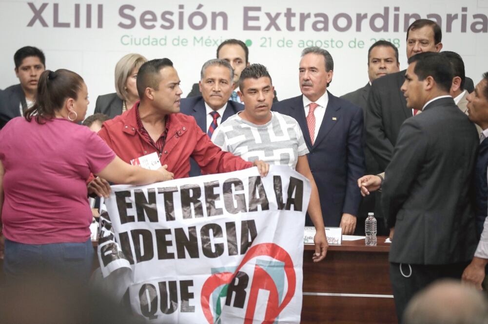 Entre empujones, el diputado local Cristian Vargas subió con una manta con una consigna en contra del presidente Enrique Peña Nieto. (JUAN CARLOS REYES. EL UNIVERSAL)