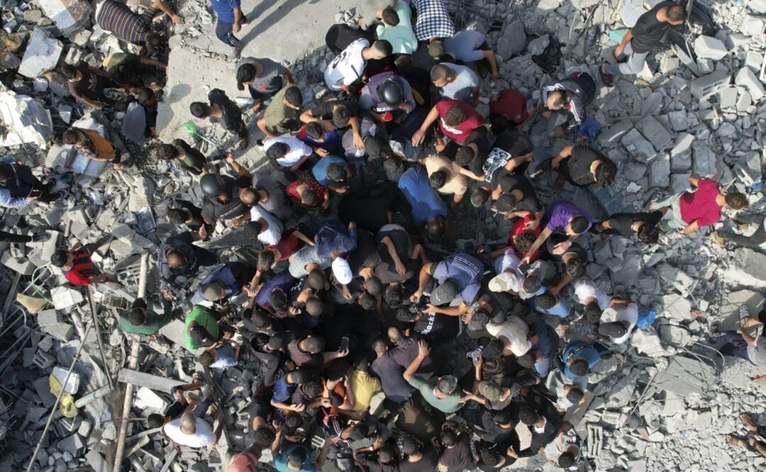 Palestinos buscan sobrevivientes entre los escombros que dejó un bombardeo israelí, el domingo 5 de noviembre de 2023, en el campamento de refugiados Maghazi, en la Franja de Gaza. Foto: AP