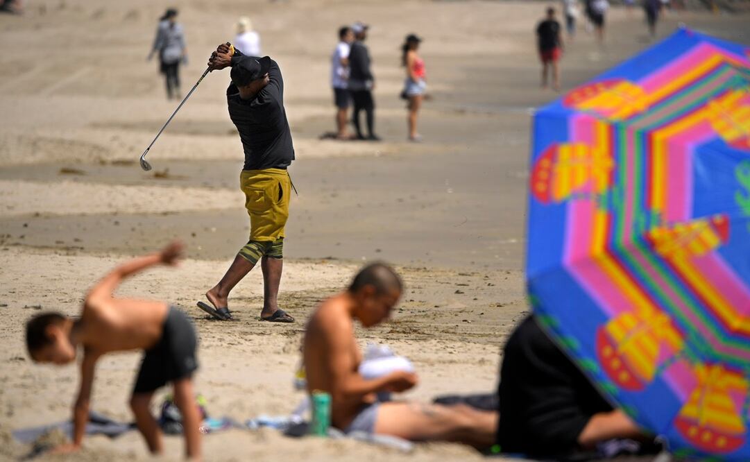 A pesar de la prohibición, con escobas, rastrillos y palas, retiran la arena que les impide practicar su pasión. Fotos: AP