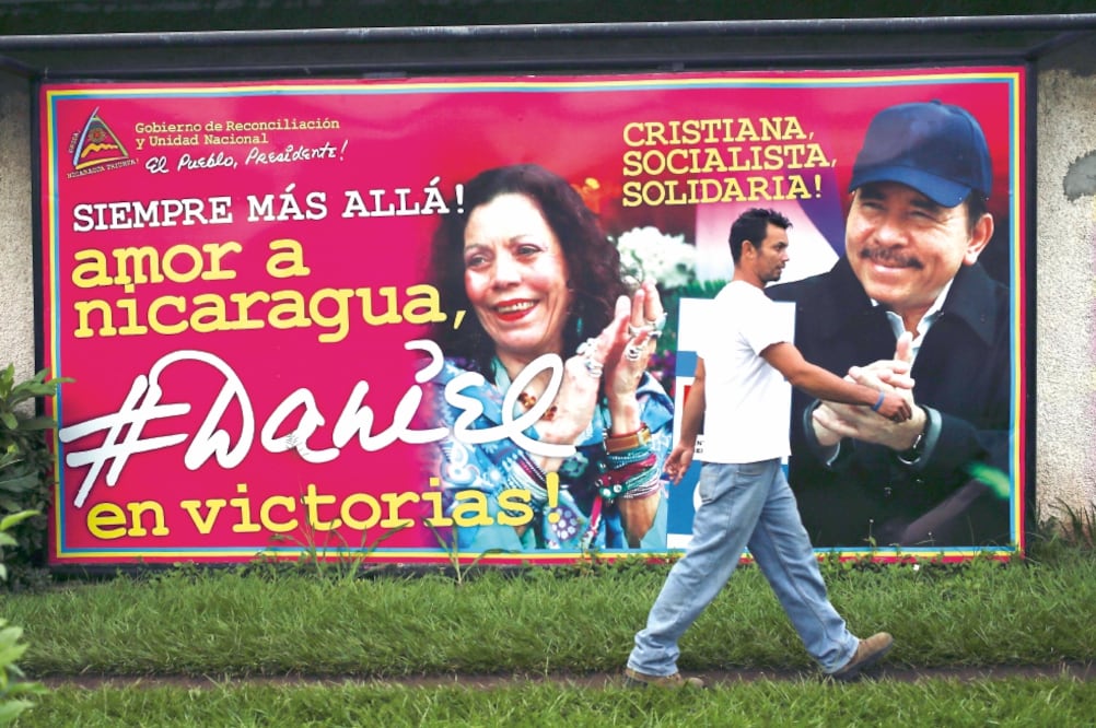 Un nicaragüense pasa junto a un cartel de propaganda de la fórmula Ortega-Murillo, en Managua. (FOTO: ESTEBAN FELIX. AP)