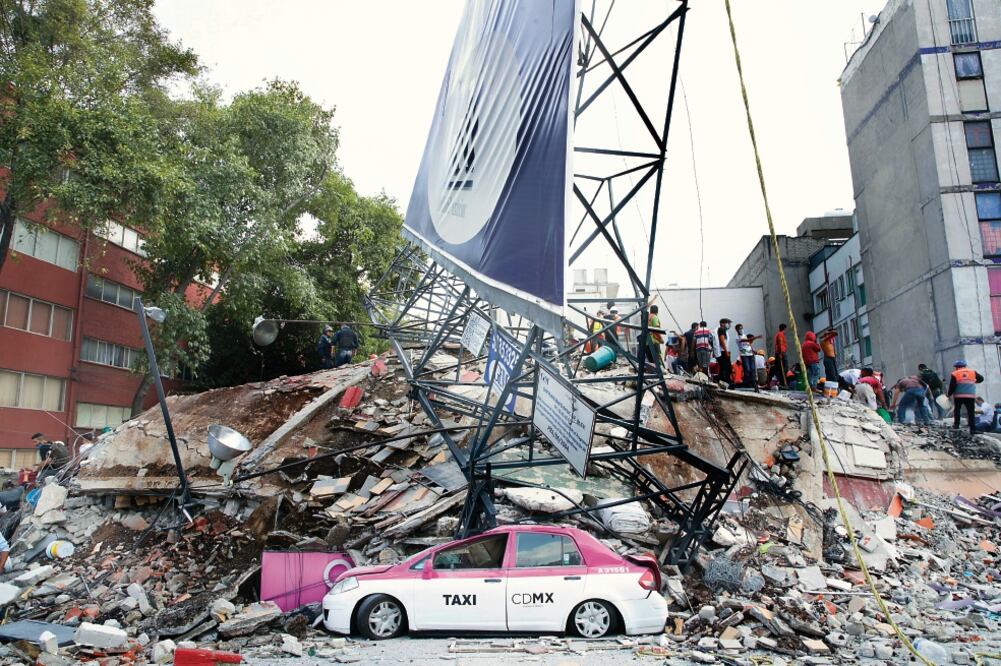 Un espectacular cayó sobre un edificio y un taxi en la calle Monterrey, donde se realizan trabajos de rescate. Varios países de Latinoamérica indicaron que enviarán miembros de su equipo de socorro (GERMÁN ESPINOSA. EL UNIVERSAL)