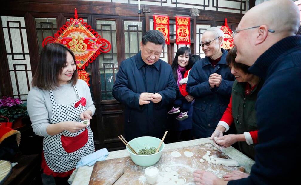 Xi Jinping conversa y hace ravioles con la familia del trabajador jubilado Zhu Maojin cuando visita un hutong, nombre con el que se conocen las calles residenciales distintivas de Beijing, en el área de Qianmen en el centro de Beijing, China, el 1 de febrero de 2019. (Xinhua/Ju Peng)