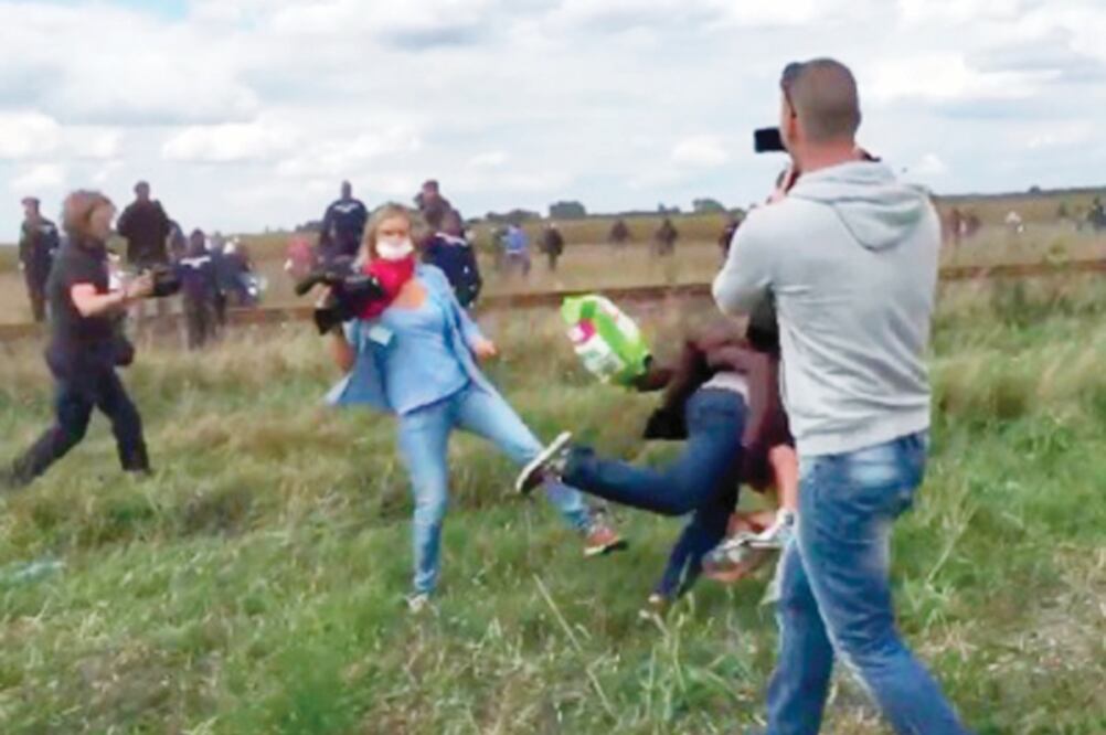 Una periodista húngara patea a refugiados sirios que intentaban escapar de un centro de registro en Roszke. La difusión en redes de las imágenes ha causado una ola de indignación. La televisora dice que la mujer ha sido despedida (STEPHAN RICHTER)