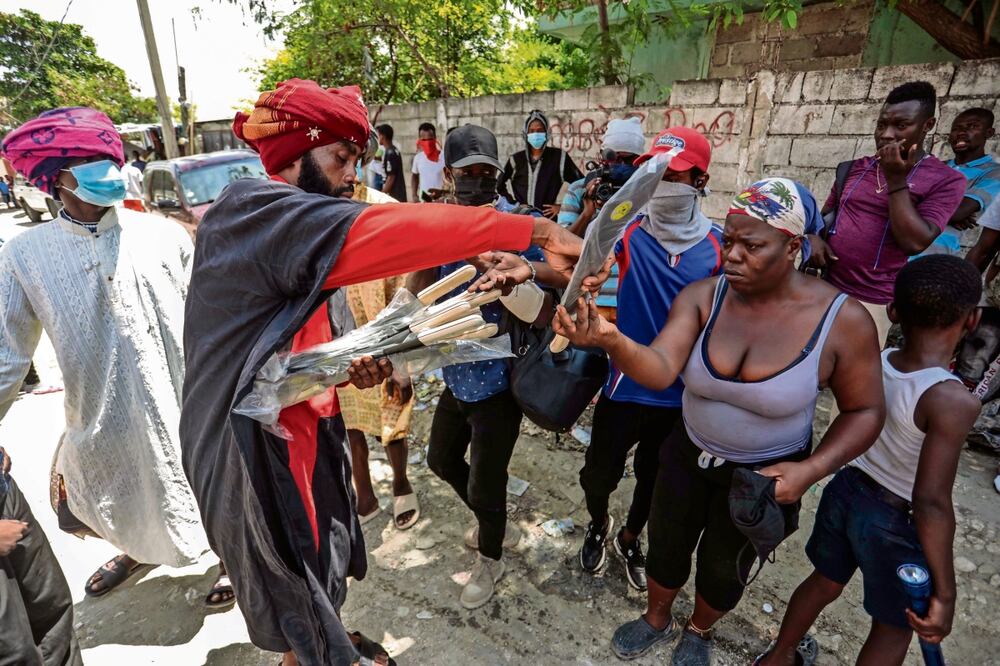Nertil Marcelin, líder de un grupo comunitario, distribuye machetes a los residentes en una iniciativa para resistir a las pandillas, en Puerto Príncipe. Foto: AP