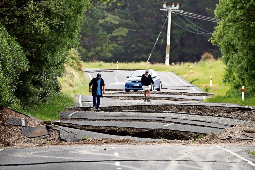 Neozelandeses, en una parte de la carretera estatal cercana a Ward, en el sur de Blenheim, en la Isla Sur. Varias vías en la zona fueron cerradas y se informó también de daños en las líneas eléctricas y telefónicas (ANTHONY PHELPS. REUTERS)