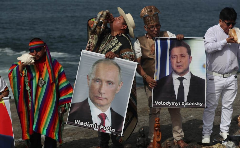 Un grupo de chamanes y curanderos sostienen imágenes de varios lideres mundiales durante un ritual de fin de año este lunes, frente al océano Pacífico en Lima (Perú). (29/12/25) Foto: EFE