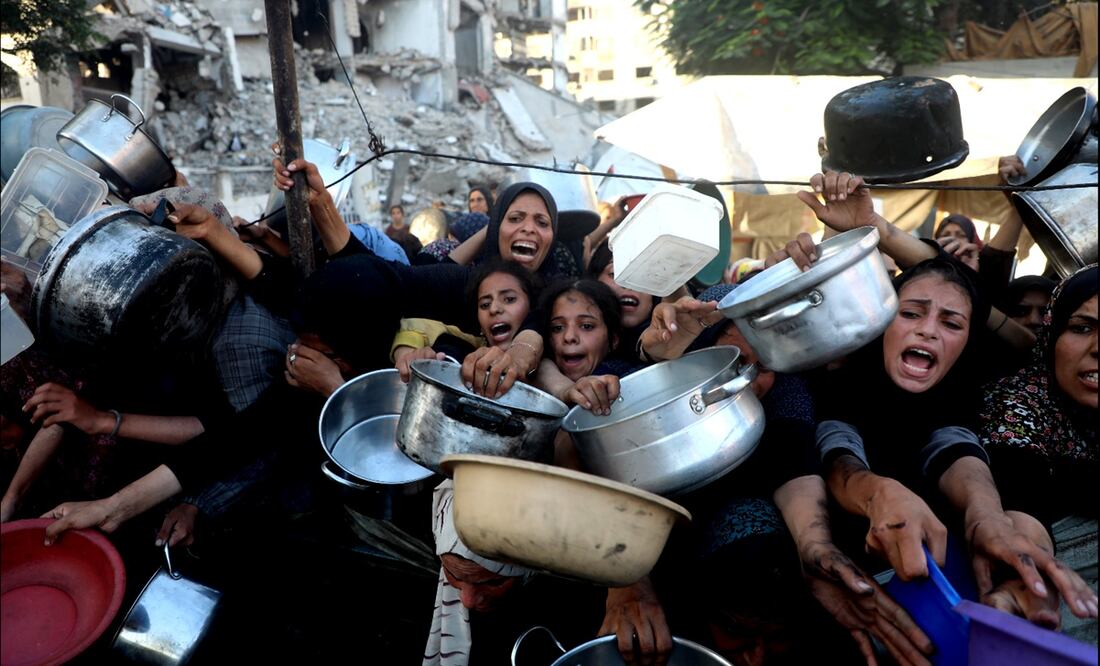 Mujeres y niños palestinos extienden sus trastes a la espera de recibir alimentos en el barrio de Al-Rimal, en la Ciudad de Gaza, el 20 de julio de 2025. El número total de muertos por hambre en Gaza desde marzo ha llegado a 86, incluidos 76 niños, dijeron las autoridades sanitarias de Gaza. Foto: Xinhua