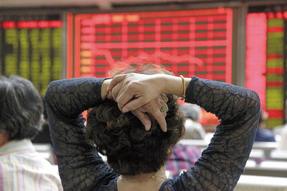 Una mujer observa la evolución de la bolsa de Shanghái en Pekín, China, la cual cerró ayer con pérdidas y arrastró a la baja a los demás mercados bursátiles (EFE. ROLEX DE LA PENA)