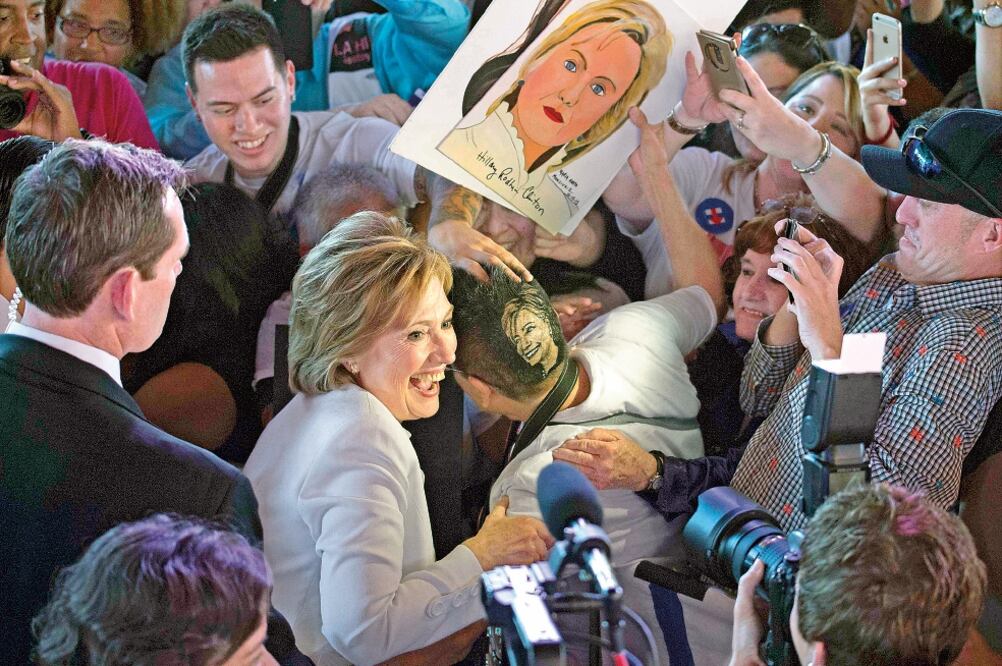 Durante un mitin en San Antonio, Texas, ayer, la aspirante presidencial demócrata Hillary Clinton se toma la foto con un simpatizante que se hizo un corte de cabello especial para dejarse la imagen de ella en la cabeza (DARREN ABATE. REUTERS)