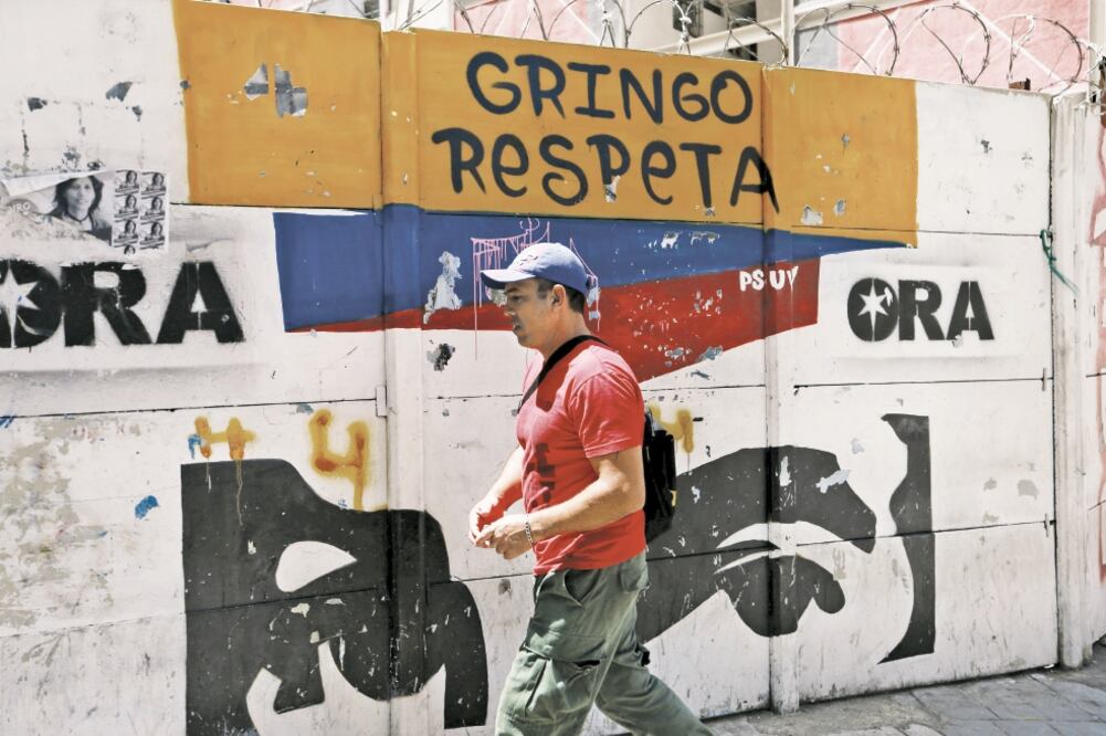 Un hombre camina frente a un grafiti con la leyenda: “Gringo respeta”, en una calle de la ciudad de Caracas, en Venezuela (ANDRÉS MARTÍNEZ. REUTERS)
