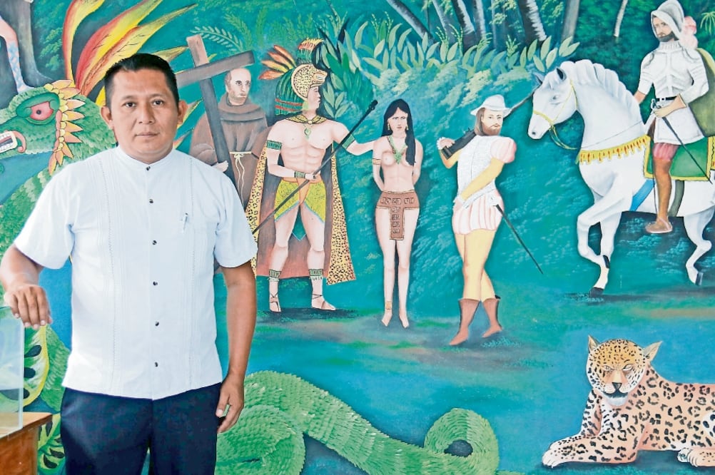 El historiador Plácido Santana junto a un mural que muestra el encuentro de chontales de Tabasco y españoles. (LUMA LÓPEZ. EL UNIVERSAL)