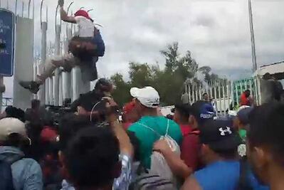 Decenas de hondureños derriban puerta en frontera gualtemalteca para llegar a México