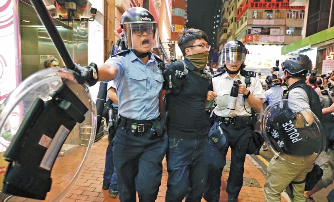 Dos oficiales de la policía de Hong Kong se enfrentaron contra los manifestantes en el barrio de Mongkok, en el norte de la ciudad. Foto/VINCENT YU. AP