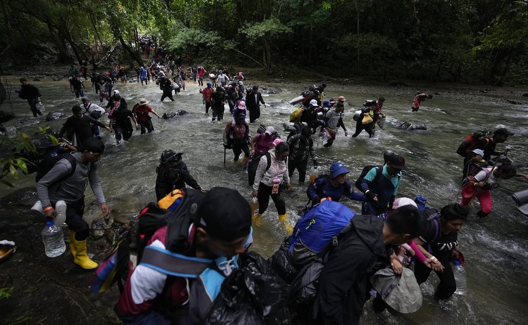 Un grupo de migrantes, en su mayoría venezolanos, cruza un río en su ruta por el Tapón del Darién. Foto: AP