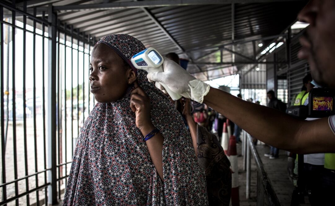 Una mujer mide su temperatura en una estación de detección de ébola cuando ingresa a la República Democrática del Congo desde Ruanda. Foto: John Wessels / AFP