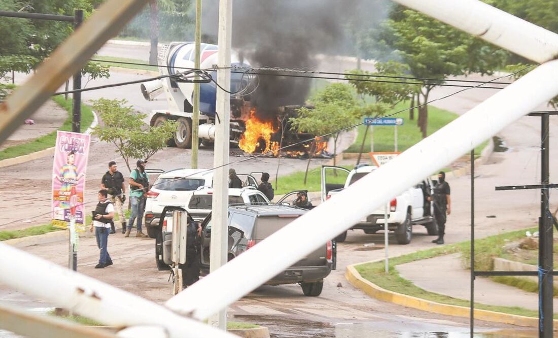 Hombres armados, señalados como integrantes del Cártel de Sinaloa, permanecieron cerca de un camión en llamas que transportaba concreto. REUTERS